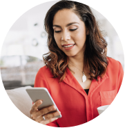 woman looking at her cellphone drinking a coffee