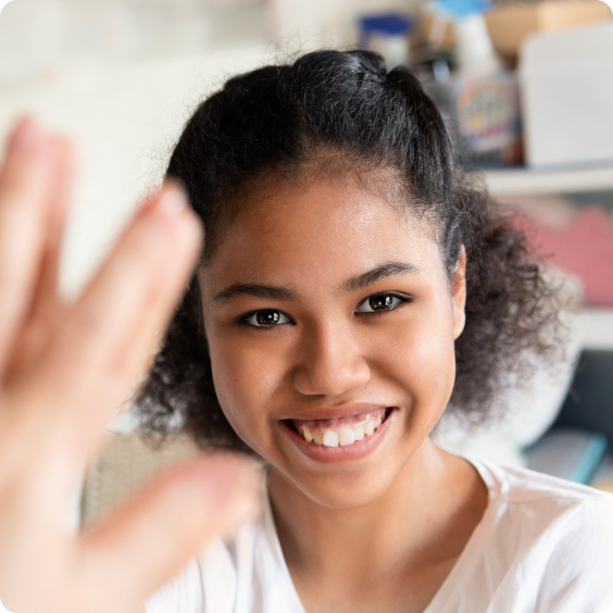 A young girl smiling in the mirror.