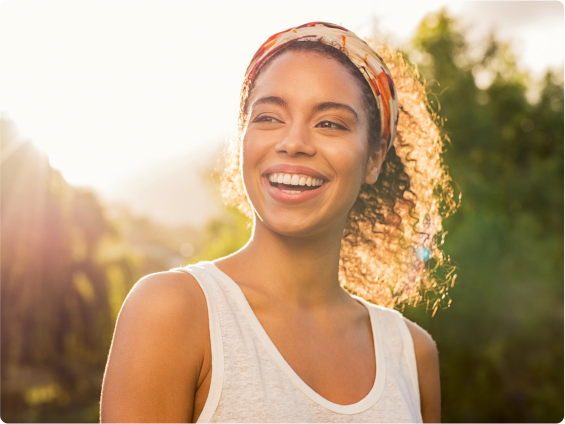 A young woman smiling outdoors.