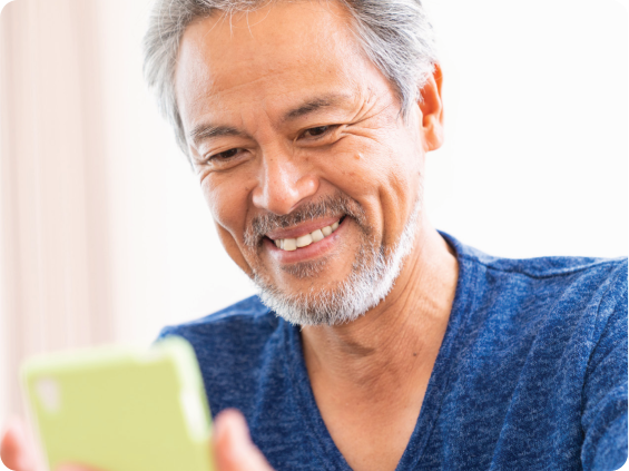 An elder gentleman looking at his cell phone.