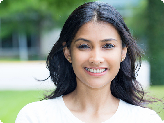 A young woman smiling outdoors.