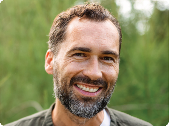 A man smiling outdoors.