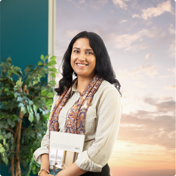 a woman standing buy a sunsetting window holding a brochure