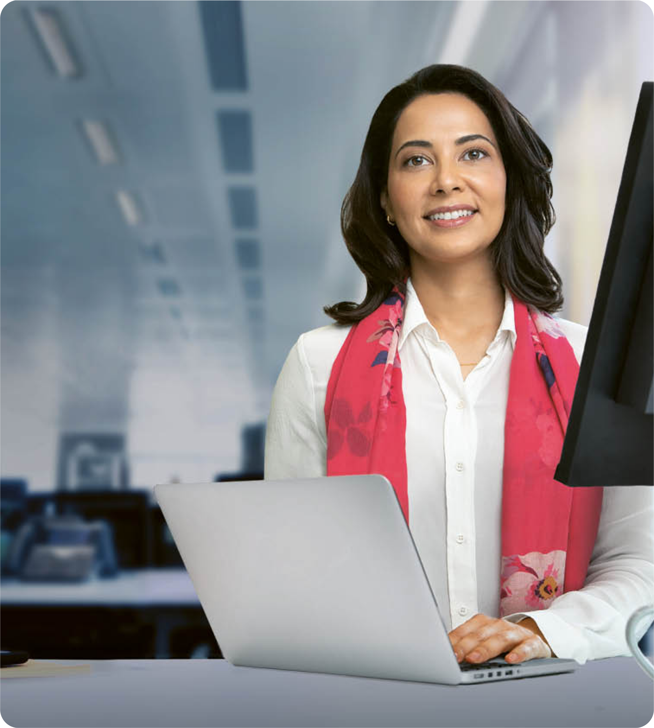 A woman in her office working on a laptop.