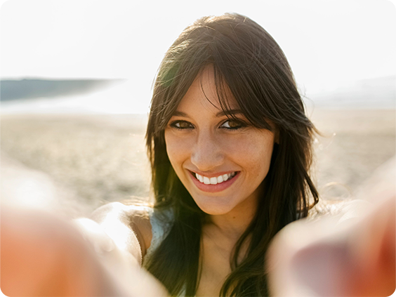 A woman taking a selfie on the beach.
