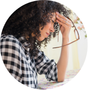woman holding her glasses with her hand on her head