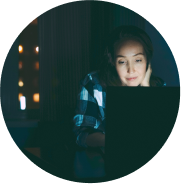 woman looking at a computer under dim lighting
