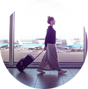 Woman walking with a carry-on bag in an airport