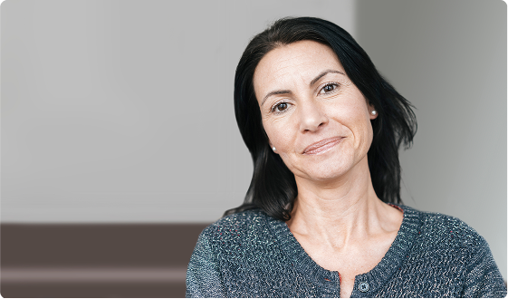 An older smiling woman with black hair